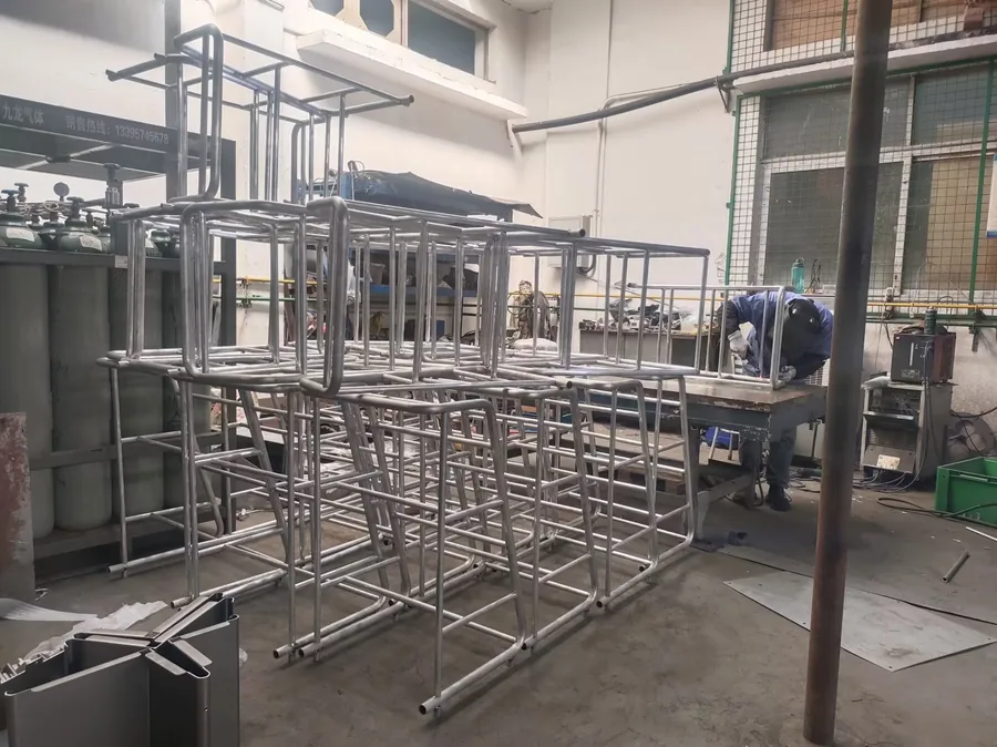 Welded stainless steel frames arranged for batch inspection.