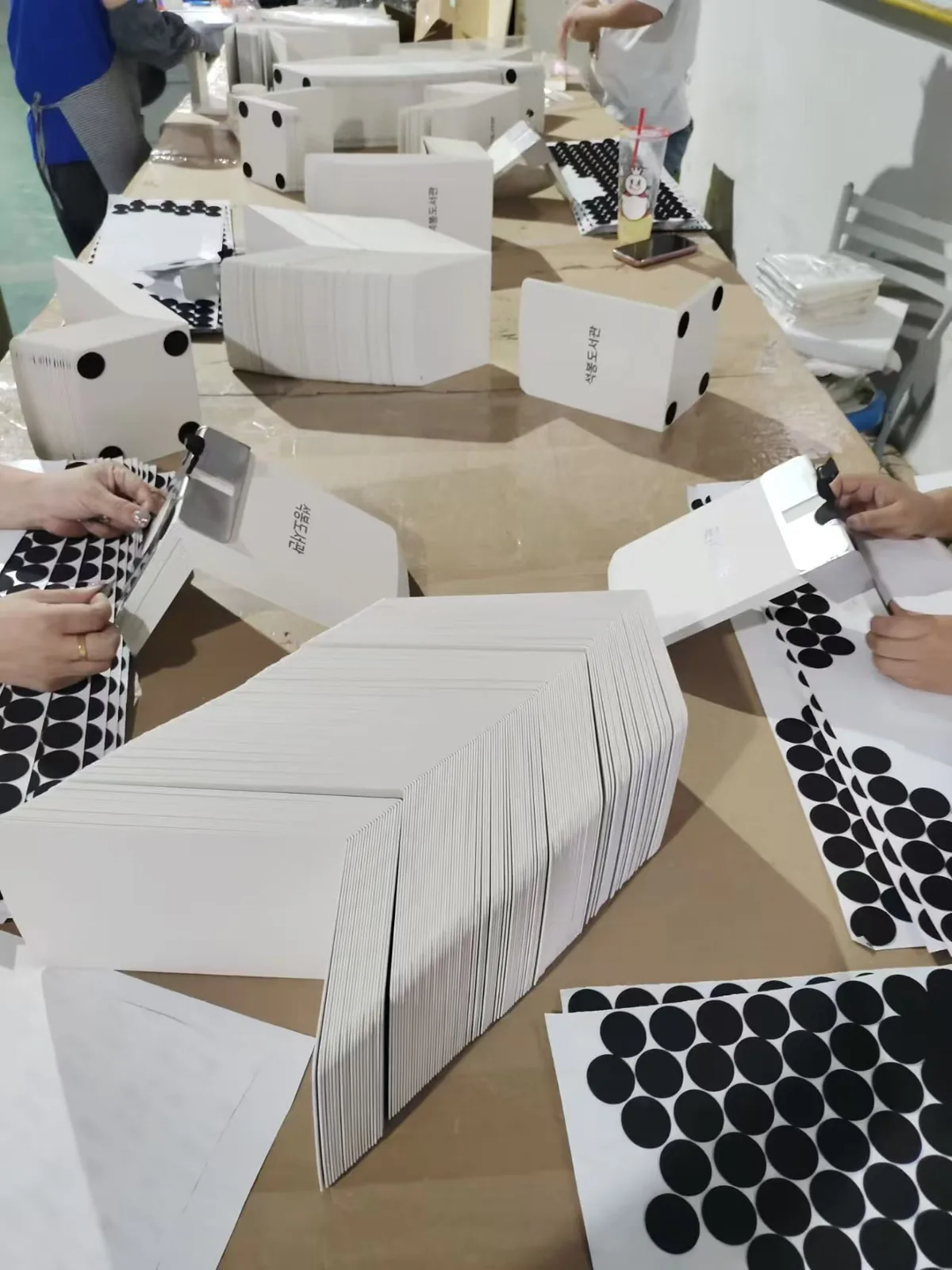 Batch assembly of folded sheet metal panels with adhesive pads applied on the line