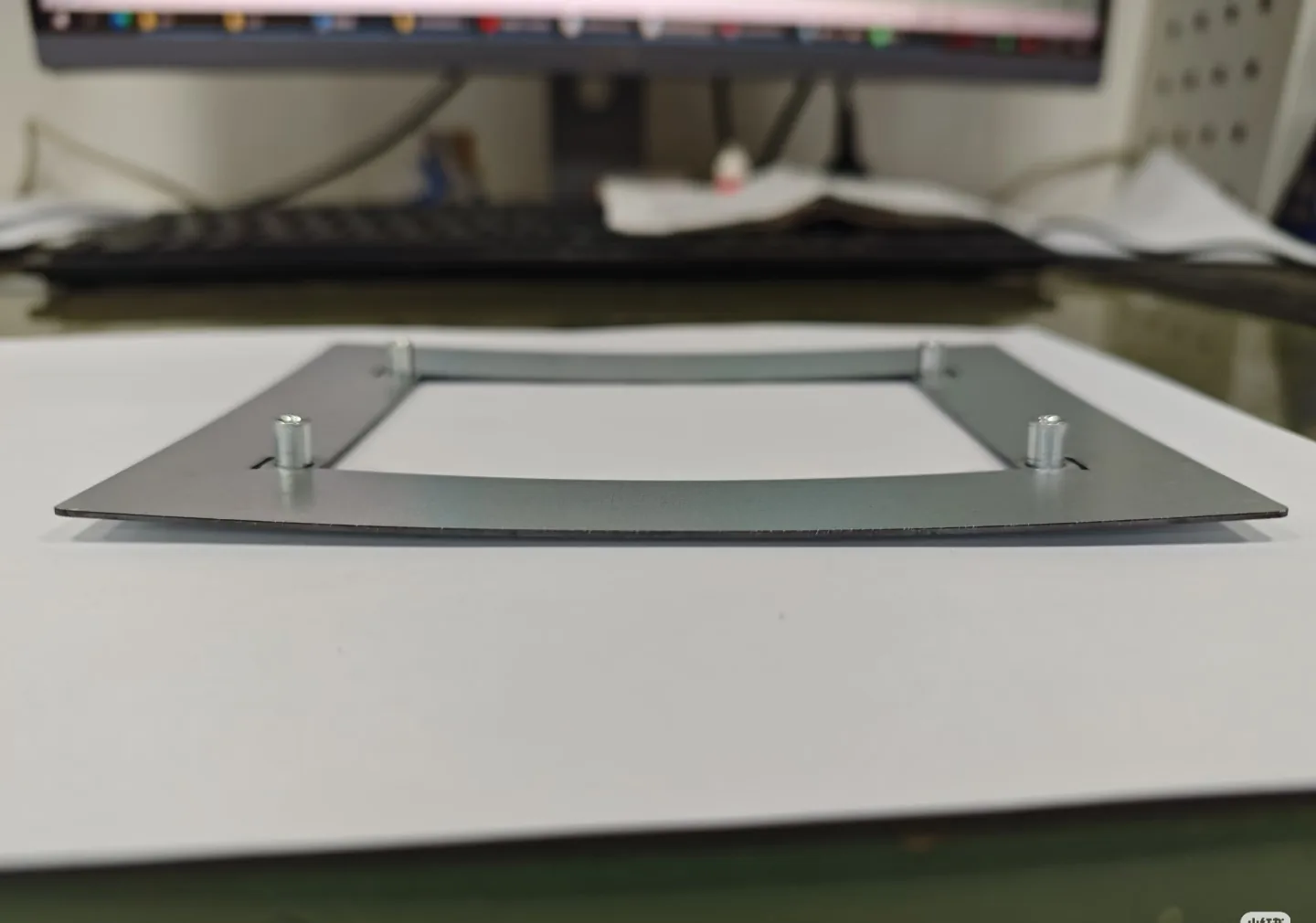 Side view of a welded stainless steel frame showing out-of-flatness from welding distortion
