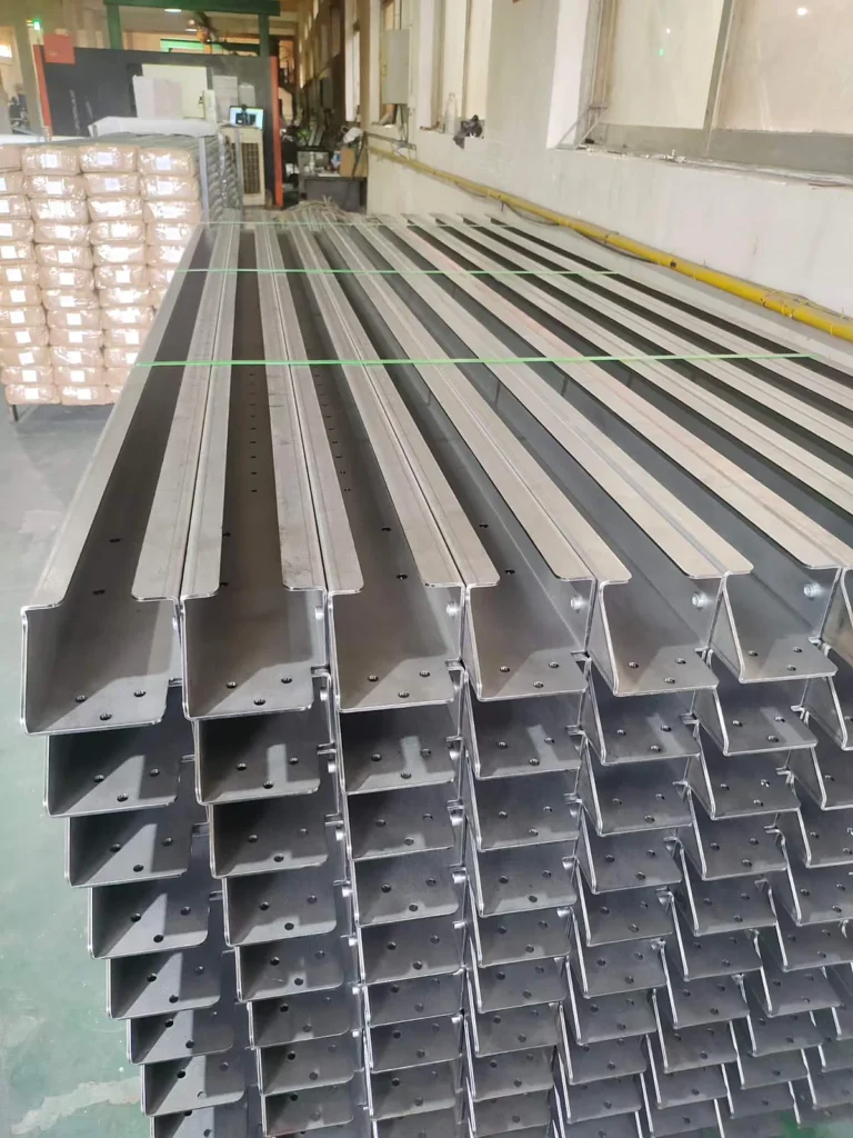 Batch of formed steel cable tray channel sections stacked in the factory