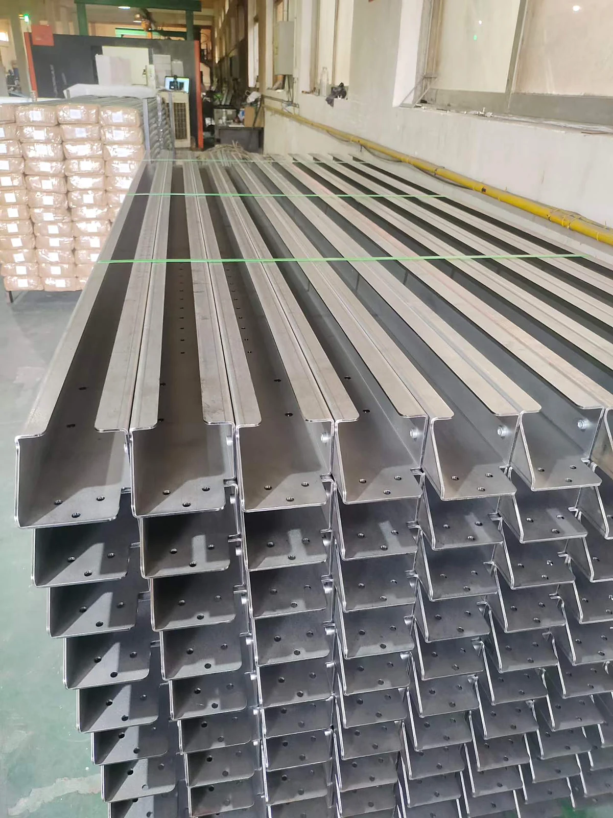 Batch of formed steel cable tray channel sections stacked in the factory