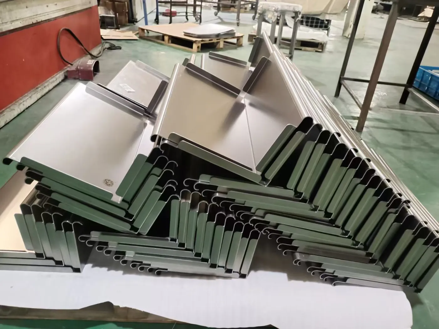 Batch of formed sheet metal panels with rolled edges stacked after press brake bending