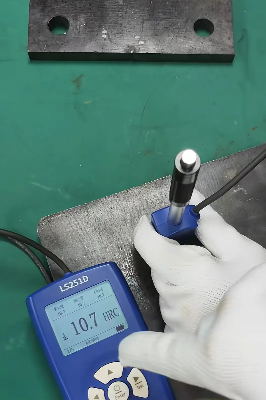 Leeb hardness tester probe pressed against the steel surface to take a hardness reading