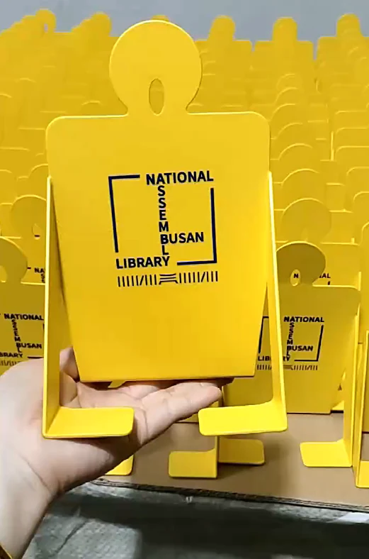 Yellow powder-coated steel library bookends with printed library logo, produced as a batch at Fulei Metal