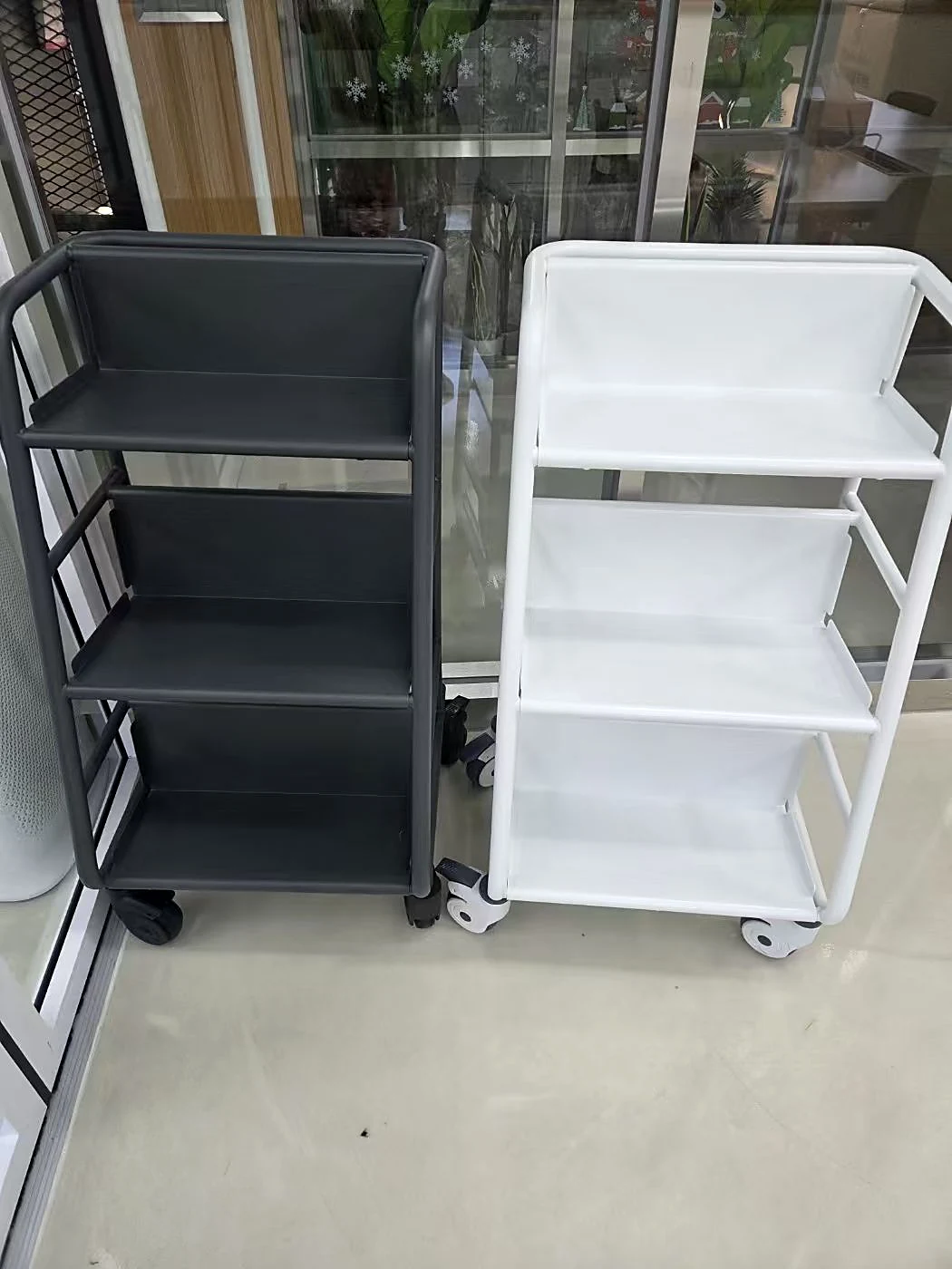 Black and white powder-coated three-tier library shelf units on castors, produced as a batch at Fulei Metal