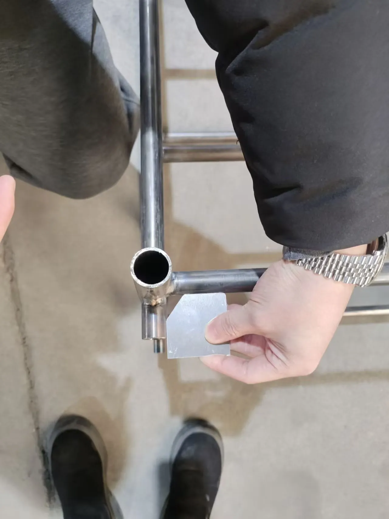 A welded joint checked against the drawing before surface treatment.