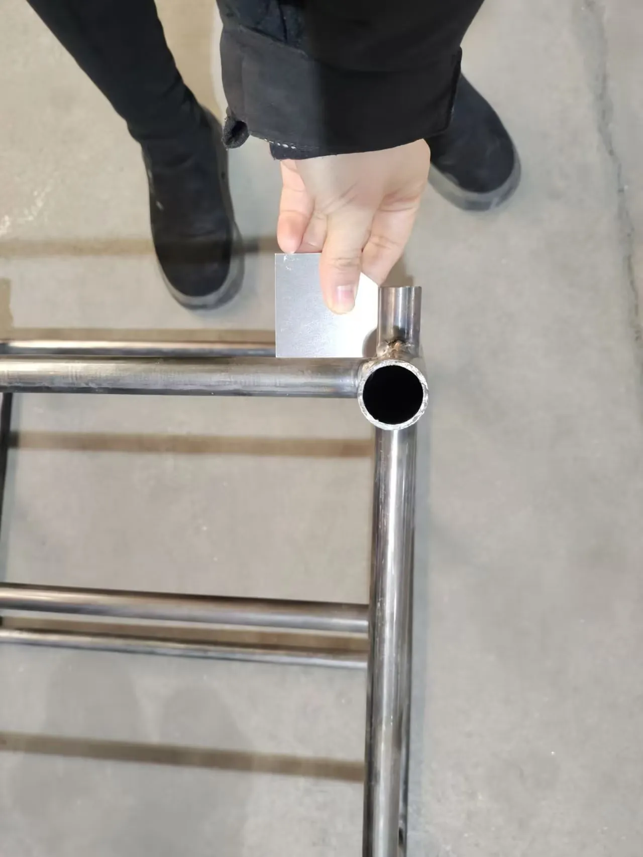 Inspector verifying the position of a welded corner on a stainless steel frame