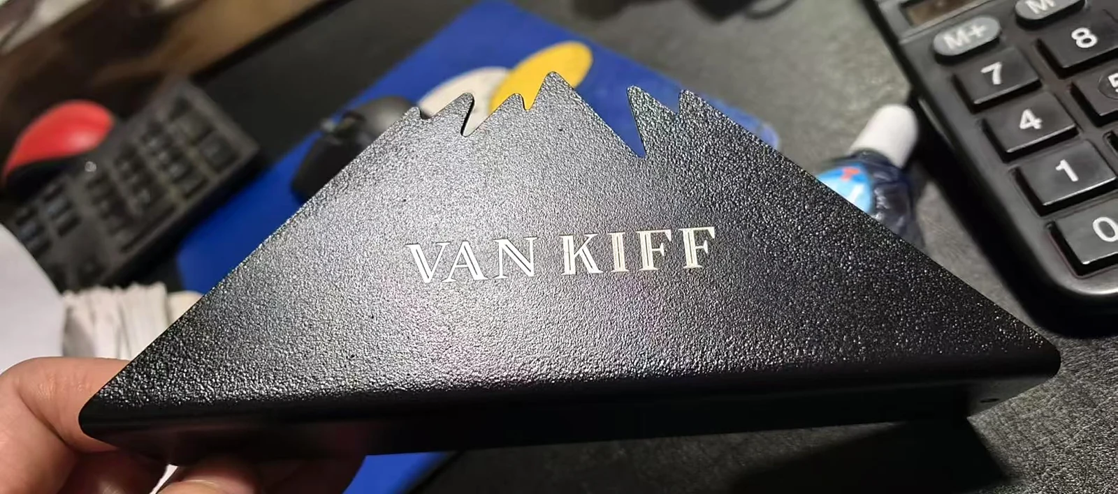 Black powder-coated sheet metal tissue holder with engraved brand lettering