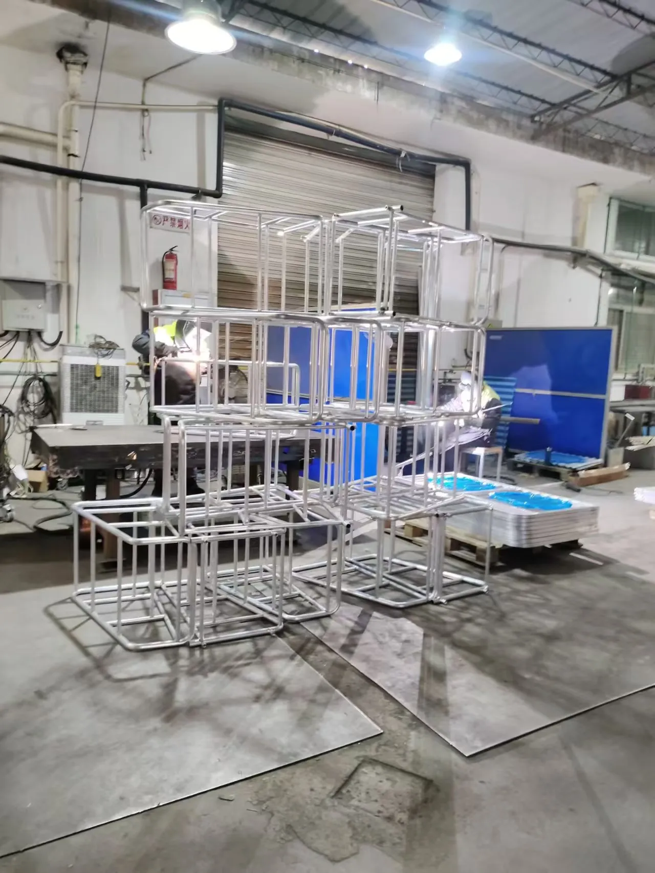 Welded frames staged in the Fulei Metal shop. A bench frame is welded in a fixture for the same reason as the other frames on this site: the seat angle, the leg spread and the flatness that stops the bench rocking are all set during assembly and cannot be corrected once the frame is galvanized.