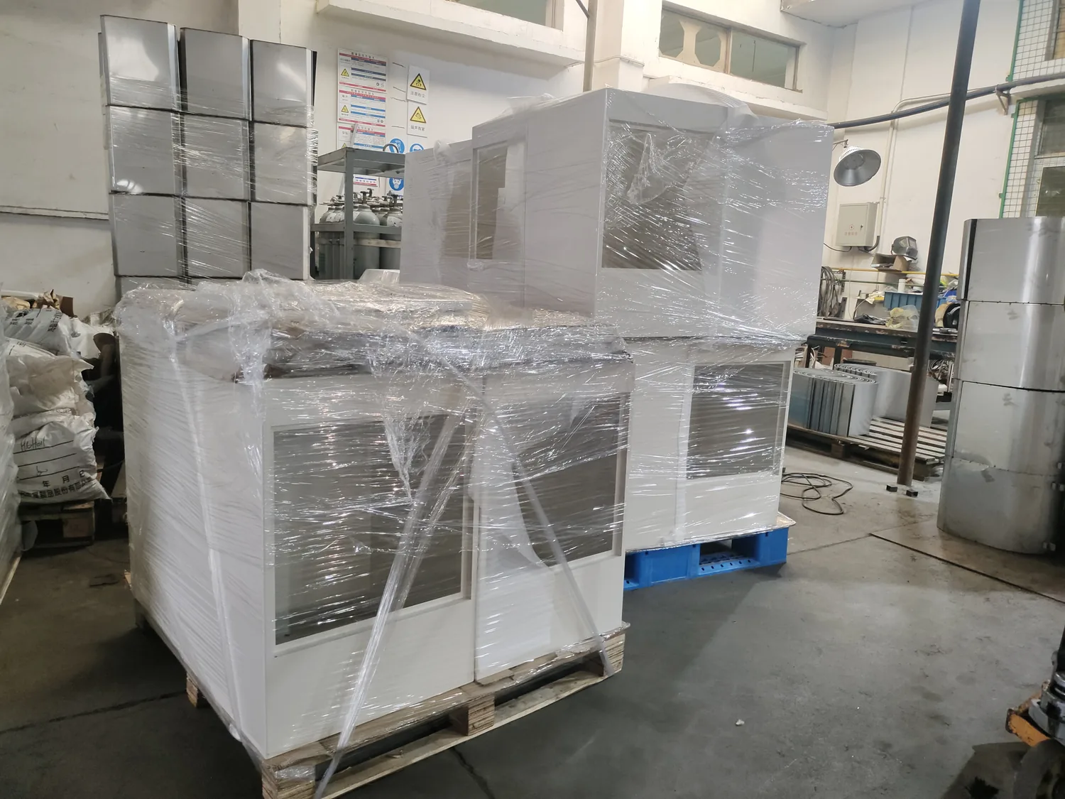 White powder coated network cabinet enclosures wrapped and staged before packing